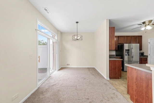 1133 Heron Cir, Joliet, IL 60431 - kitchen featuring appliances with stainless steel finishes, light colored carpet, a chandelier, light countertops, and pendant lighting