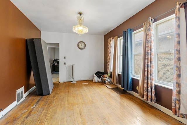 7637 S Ridgeland Ave, Chicago, IL 60649 - unfurnished dining area featuring hardwood / wood-style floors, a chandelier, and baseboards