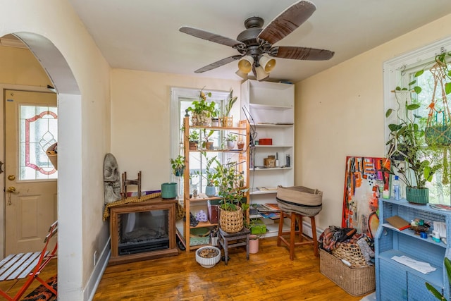 605 N Jefferson St, Harvard, IL 60033 - living area with arched walkways, wood finished floors, a ceiling fan, and a baseboard heating unit