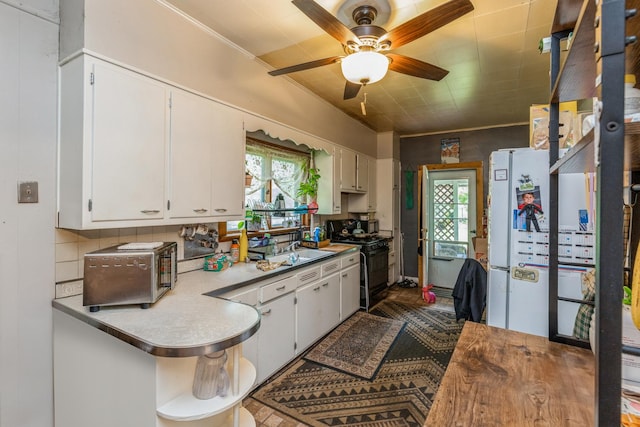605 N Jefferson St, Harvard, IL 60033 - kitchen featuring gas stove, freestanding refrigerator, white cabinetry, a ceiling fan, and crown molding