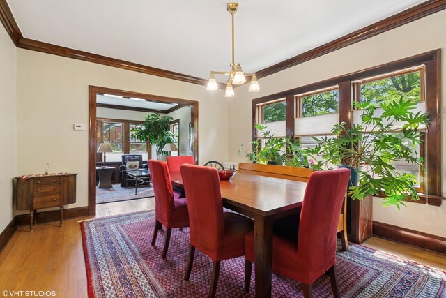 2558 W Cullom Ave, Chicago, IL 60618 - dining area featuring crown molding, light wood-style flooring, and a chandelier