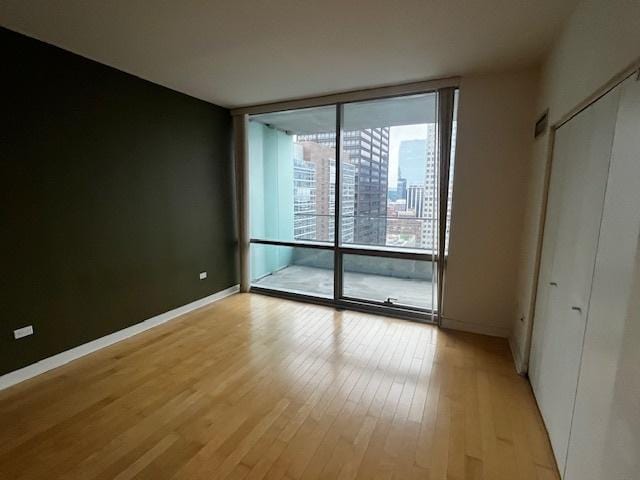 8 E Randolph St Unit 3206, Chicago, IL 60601 - unfurnished bedroom featuring expansive windows, light wood-style floors, and baseboards