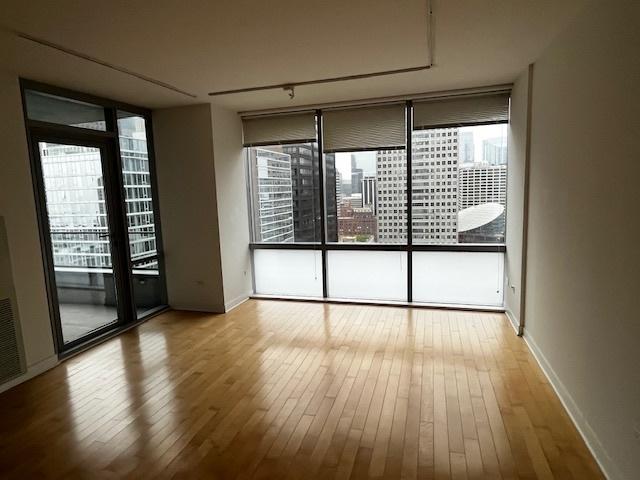 8 E Randolph St Unit 3206, Chicago, IL 60601 - unfurnished room with hardwood / wood-style floors, expansive windows, and baseboards