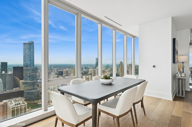 363 E Wacker Dr Unit 6301, Chicago, IL 60601 - dining area featuring a view of city, wood finished floors, and baseboards