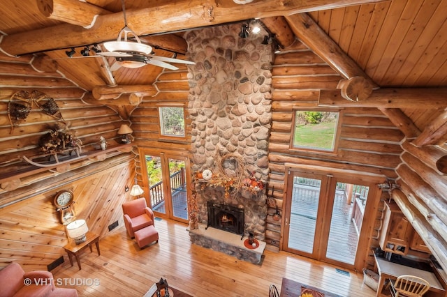 2317 Paulson Rd, Harvard, IL 60033 - unfurnished living room featuring ceiling fan, hardwood / wood-style floors, wood ceiling with exposed beams, a stone fireplace, and plenty of natural light
