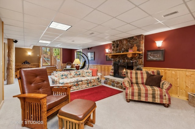 2317 Paulson Rd, Harvard, IL 60033 - living area with wood walls, carpet, a stone fireplace, a wainscoted wall, and a paneled ceiling