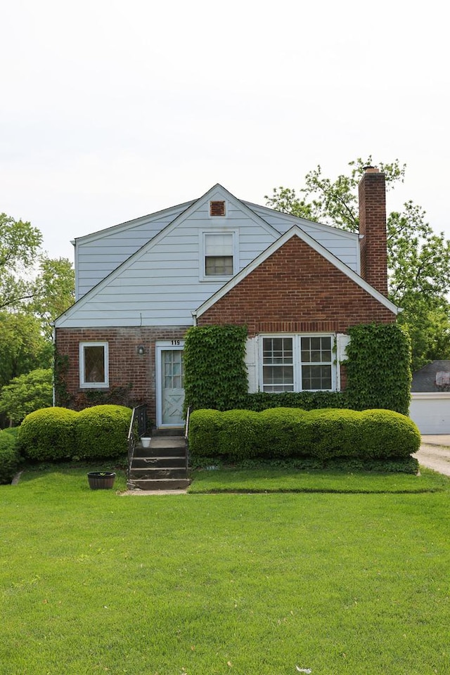119 Happ Rd, Northfield, IL 60093 - view of front facade with brick siding, a front lawn, and a chimney