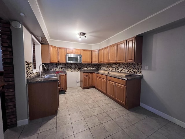 409 Winnemac St, Park Forest, IL 60466 - kitchen with a sink, stainless steel microwave, backsplash, dark countertops, and light tile patterned floors