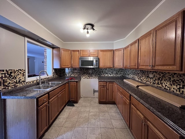 409 Winnemac St, Park Forest, IL 60466 - kitchen with stainless steel microwave, a sink, brown cabinetry, decorative backsplash, and crown molding