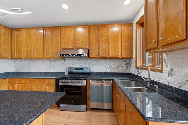 1019 W 47th Pl, Chicago, IL 60609 - kitchen featuring stainless steel appliances, extractor fan, dark stone countertops, decorative backsplash, and light wood-type flooring