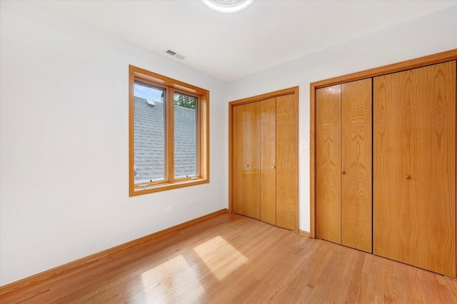 1019 W 47th Pl, Chicago, IL 60609 - unfurnished bedroom featuring multiple closets and light wood-type flooring