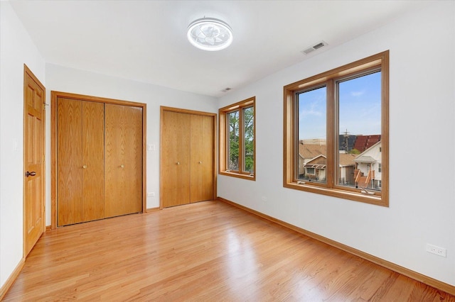1019 W 47th Pl, Chicago, IL 60609 - unfurnished bedroom with two closets and light wood-type flooring