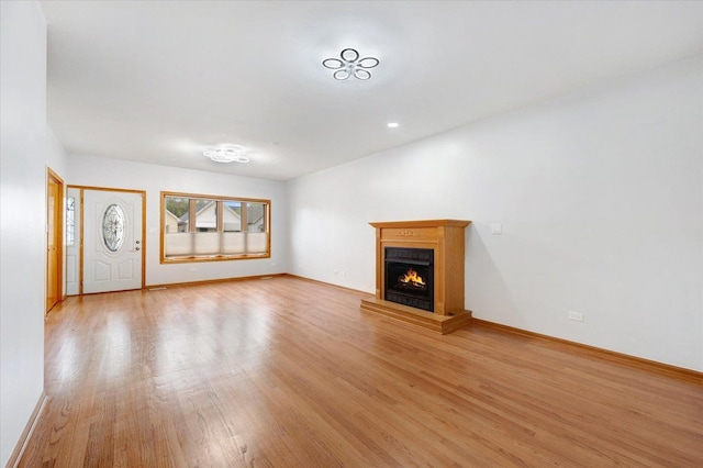 1019 W 47th Pl, Chicago, IL 60609 - unfurnished living room featuring light wood finished floors and a lit fireplace