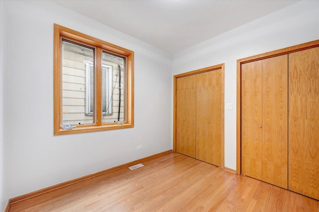 1019 W 47th Pl, Chicago, IL 60609 - unfurnished bedroom featuring light wood finished floors and multiple closets
