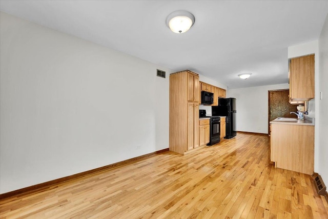901 E Ardyce Ln, Mount Prospect, IL 60056 - kitchen with black appliances, light wood-style floors, and light countertops