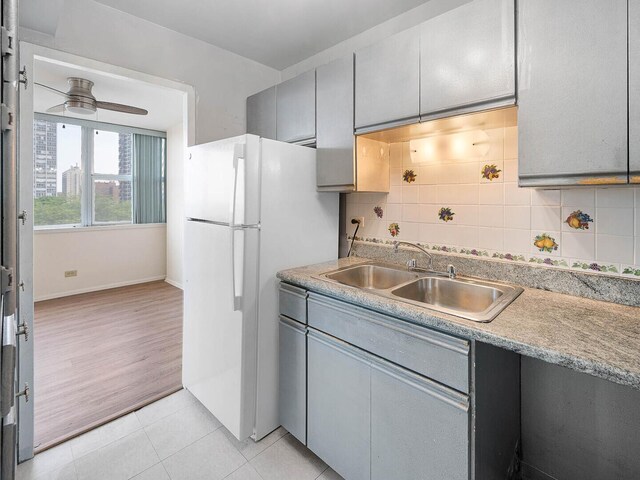 6301 N Sheridan Rd Unit 7G, Chicago, IL 60660 - kitchen featuring gray cabinetry, freestanding refrigerator, a sink, tasteful backsplash, and light tile patterned floors