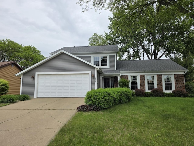 2206 11th Ave, Sterling, IL 61081 - traditional-style house with concrete driveway, a front yard, a garage, brick siding, and roof with shingles