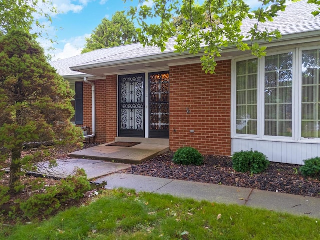 212 Mays Dr, Bloomington, IL 61701 - view of exterior entry featuring brick siding and a shingled roof