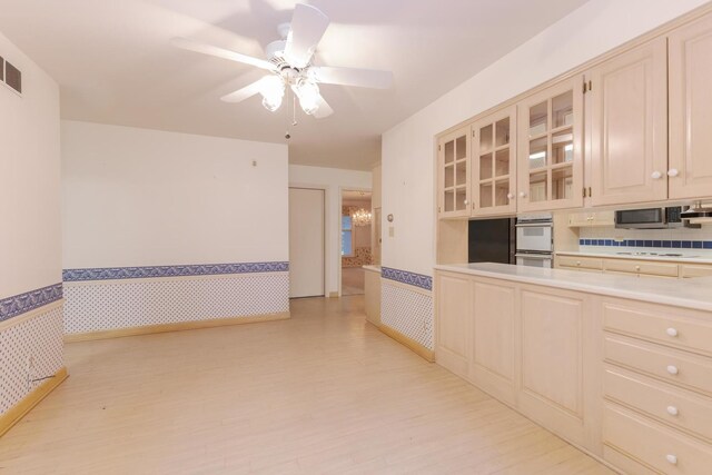 212 Mays Dr, Bloomington, IL 61701 - kitchen featuring light countertops, white double oven, stainless steel microwave, glass insert cabinets, and wallpapered walls