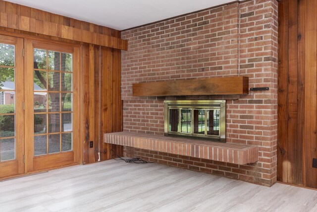 212 Mays Dr, Bloomington, IL 61701 - unfurnished living room with a brick fireplace, wood finished floors, and wooden walls