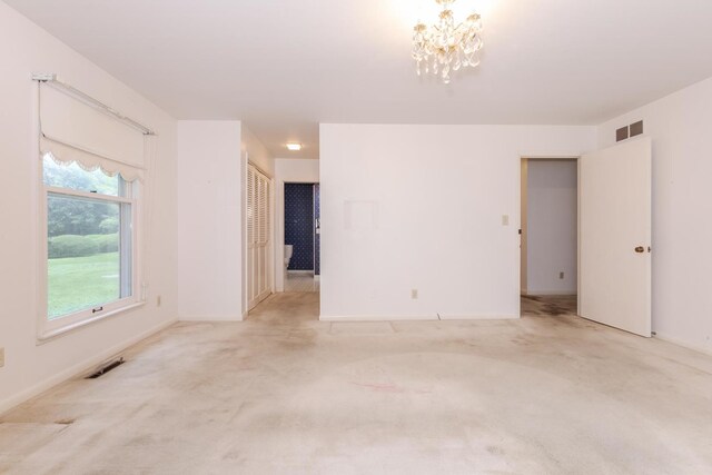 212 Mays Dr, Bloomington, IL 61701 - unfurnished room with a chandelier, light carpet, and baseboards