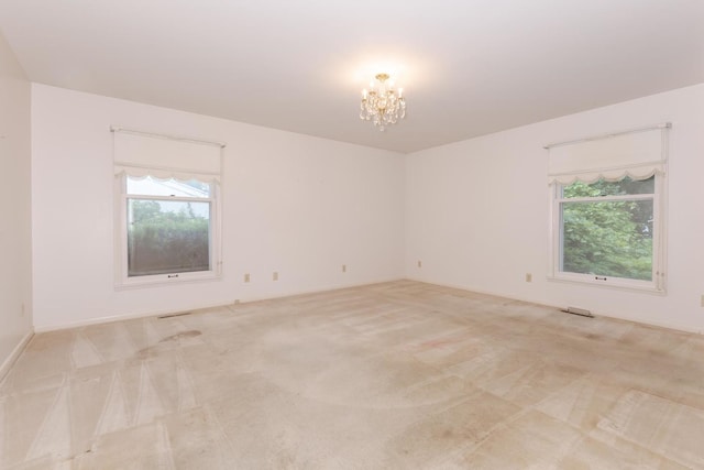212 Mays Dr, Bloomington, IL 61701 - unfurnished room with light colored carpet and a chandelier