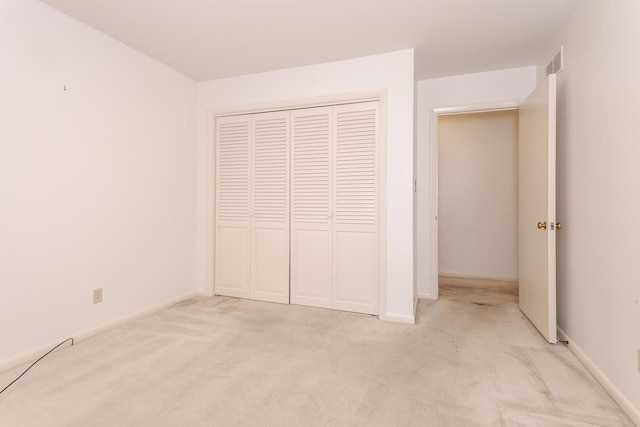 212 Mays Dr, Bloomington, IL 61701 - unfurnished bedroom featuring light colored carpet, a closet, and baseboards
