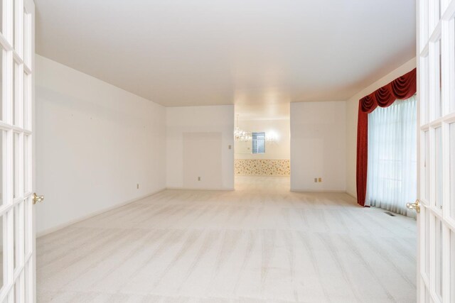 212 Mays Dr, Bloomington, IL 61701 - unfurnished room featuring light carpet and a chandelier