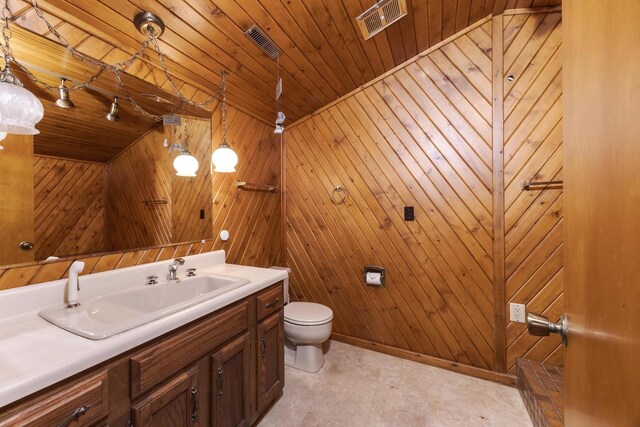 212 Mays Dr, Bloomington, IL 61701 - bathroom with toilet, vanity, and wooden walls