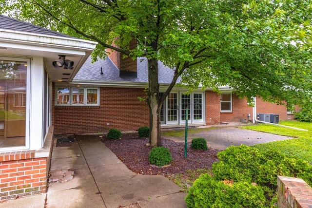 212 Mays Dr, Bloomington, IL 61701 - view of side of property with a patio, roof with shingles, brick siding, and cooling unit
