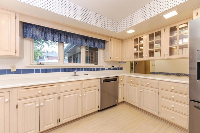 212 Mays Dr, Bloomington, IL 61701 - kitchen with stainless steel appliances, a sink, light countertops, glass insert cabinets, and light wood finished floors