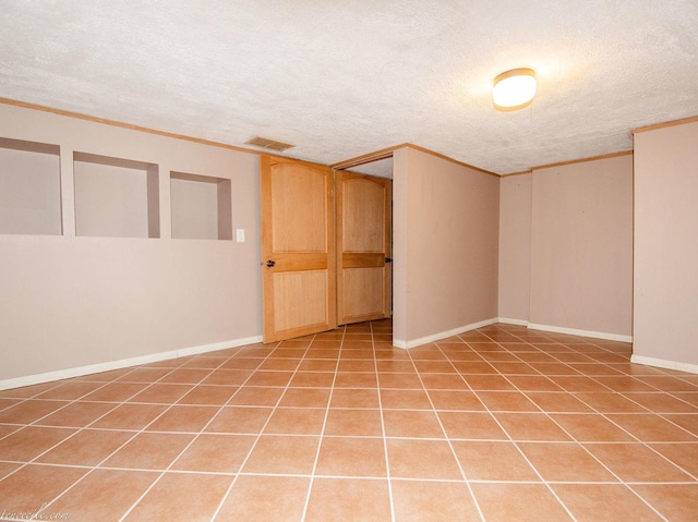 444 S Tanner Ave, Kankakee, IL 60901 - finished basement featuring a textured ceiling, crown molding, and light tile patterned flooring