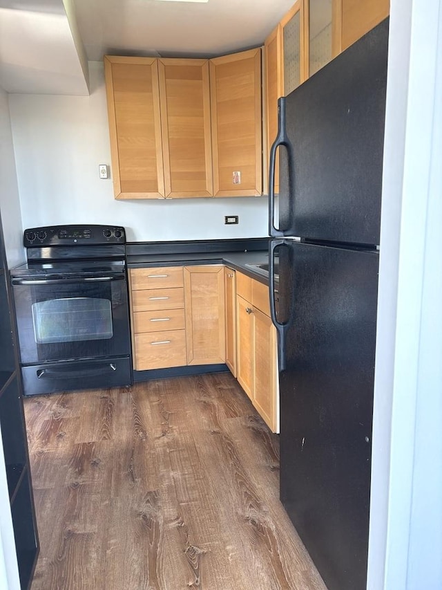 6301 N Sheridan Rd Unit 5H, Chicago, IL 60660 - kitchen with black appliances, light brown cabinets, dark wood-style floors, dark countertops, and glass insert cabinets