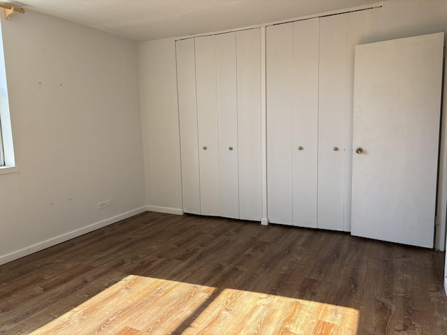 6301 N Sheridan Rd Unit 5H, Chicago, IL 60660 - unfurnished bedroom featuring dark wood-style floors and two closets