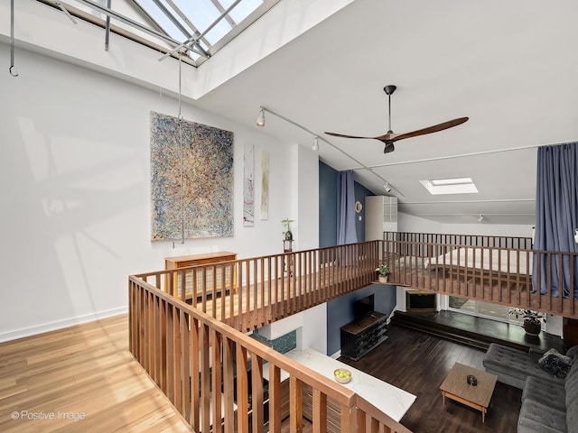 241 E Burlington St Unit A, Riverside, IL 60546 - stairway featuring ceiling fan, a skylight, wood finished floors, baseboards, and rail lighting