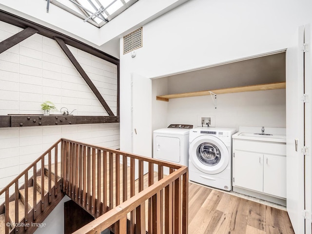 241 E Burlington St Unit A, Riverside, IL 60546 - washroom with cabinet space, washing machine and clothes dryer, and light wood-style flooring