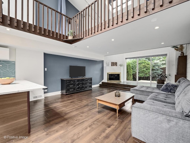 241 E Burlington St Unit A, Riverside, IL 60546 - living area featuring wood finished floors, a glass covered fireplace, baseboards, a towering ceiling, and recessed lighting