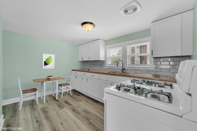 10002 S Torrence Ave, Chicago, IL 60617 - kitchen featuring a sink, butcher block countertops, light wood-style floors, tasteful backsplash, and white cabinets