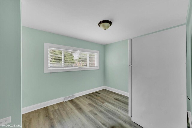10002 S Torrence Ave, Chicago, IL 60617 - unfurnished bedroom with wood finished floors, baseboards, and a closet