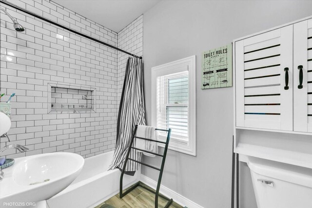 10002 S Torrence Ave, Chicago, IL 60617 - bathroom featuring a sink, shower / tub combo with curtain, toilet, baseboards, and wood finished floors