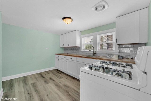 10002 S Torrence Ave, Chicago, IL 60617 - kitchen featuring a sink, decorative backsplash, light wood finished floors, and white cabinets