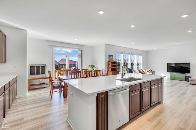 1214 Buckeye Cir, Crystal Lake, IL 60012 - kitchen with stainless steel dishwasher, a sink, open floor plan, light wood-style floors, and light countertops