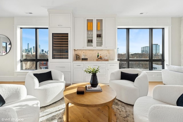1812 N Howe St Unit Ph, Chicago, IL 60614 - living area featuring beverage cooler, a skyline view, plenty of natural light, and crown molding