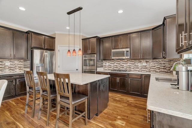 1221 Winding Way, Bolingbrook, IL 60490 - kitchen with stainless steel appliances, ornamental molding, dark brown cabinetry, tasteful backsplash, and a breakfast bar