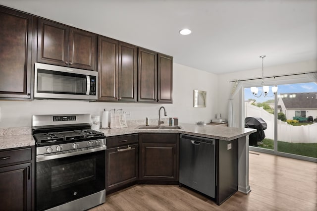 1025 Tuscany Trl, Hampshire, IL 60140 - kitchen with stainless steel appliances, a sink, light wood finished floors, a peninsula, and dark brown cabinets