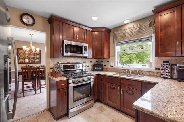 140 Amherst Dr, Bartlett, IL 60103 - kitchen with appliances with stainless steel finishes, a chandelier, light stone counters, tasteful backsplash, and recessed lighting