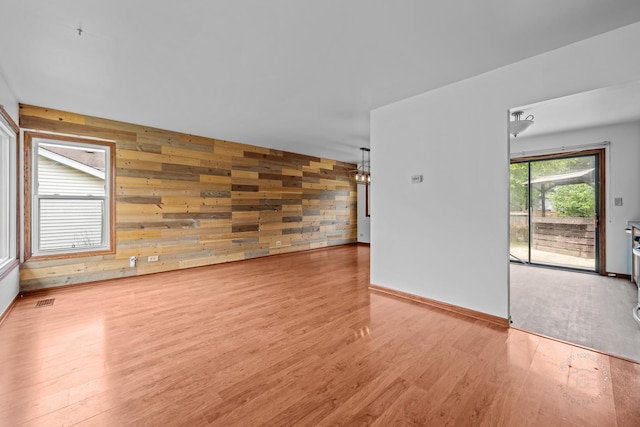 304 Dean Cir, Bolingbrook, IL 60440 - empty room featuring wooden walls, wood finished floors, and a chandelier
