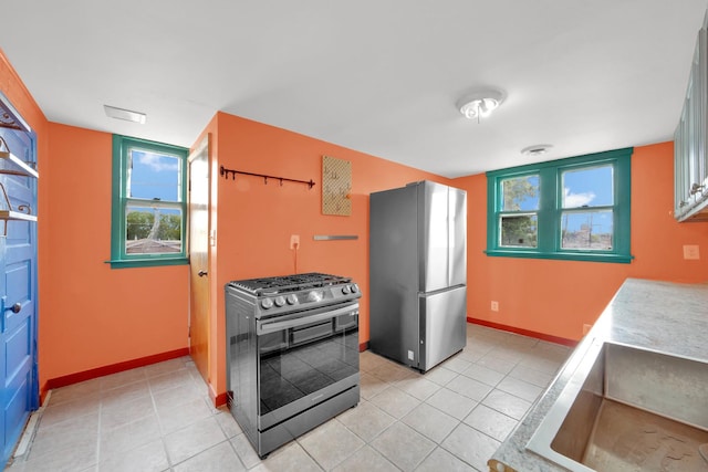 4501 S Kilpatrick Ave, Chicago, IL 60632 - kitchen with stainless steel appliances, light tile patterned flooring, baseboards, and healthy amount of natural light
