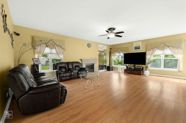 7623 Beringer Ct, Gurnee, IL 60031 - living area featuring plenty of natural light, a glass covered fireplace, light wood-style flooring, and ceiling fan