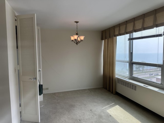 4800 S Chicago Beach Dr Unit 910S, Chicago, IL 60615 - spare room featuring a chandelier, light carpet, and radiator heating unit